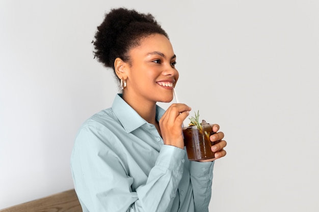 Foto donna che fa una pausa caffè ghiacciata fuori