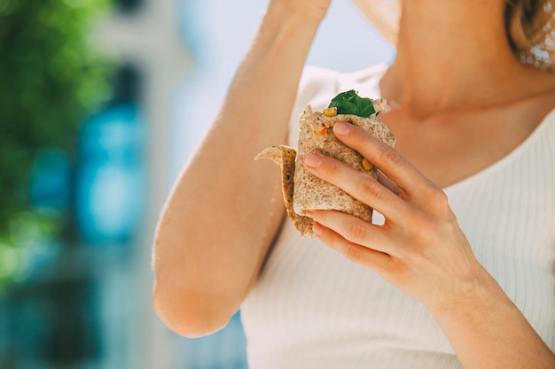 Woman having lunch break outside, partial view