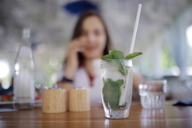 Woman having lunch in summer restaurant blurred background