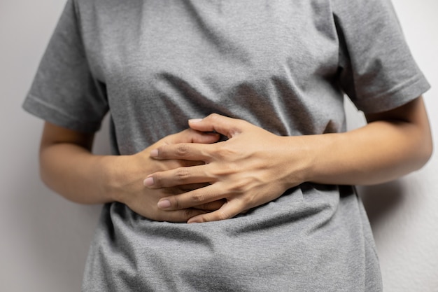 Donna che ha mal di stomaco doloroso. giovane donna con dolore addominale dovuto alle mestruazioni. dolore addominale dovuto alla gastrite.