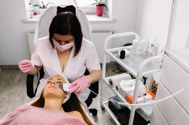 Woman having a stimulating facial treatment from a therapist