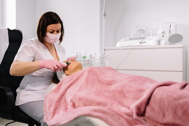 Woman having a stimulating facial treatment from a therapist