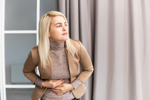 写真 家でお腹が痛い女性。