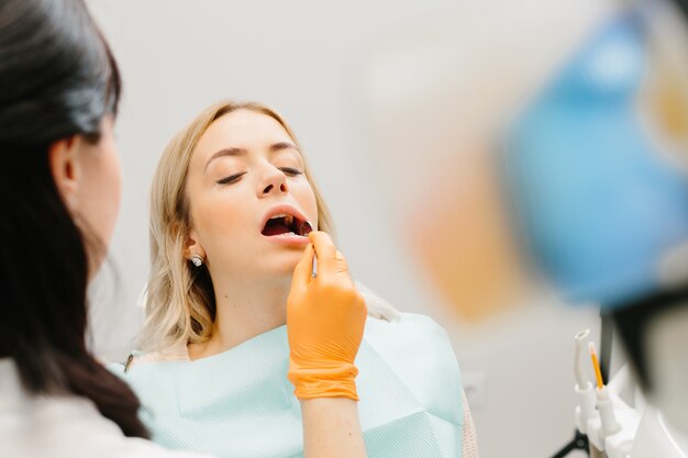 Женщина осматривает зубы у стоматолога