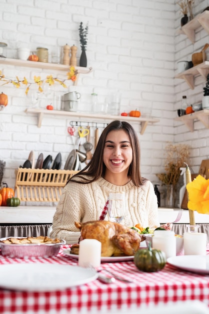 Donna che mangia la cena del ringraziamento nella cucina di casa che celebra le vacanze