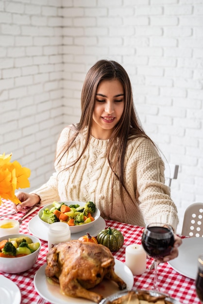 Woman having thanksgiving dinner at home kitchen celebrating holiday