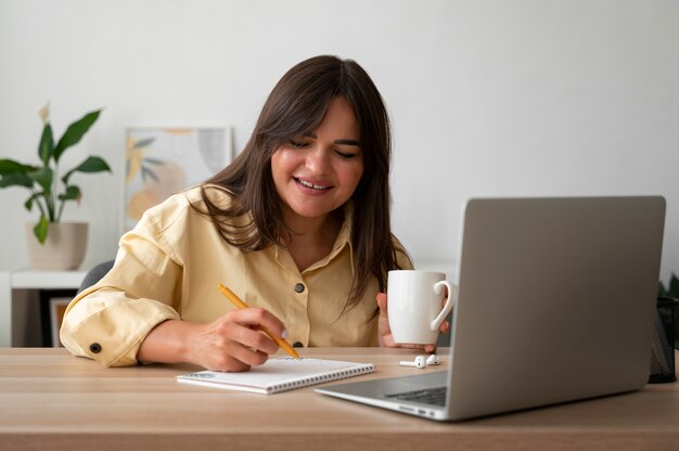 Photo woman having a video call at home on a laptop device