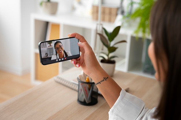 Photo woman having a video call at home with a smartphone device