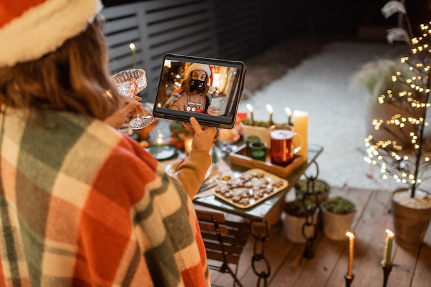 Woman having a video call with a friend during a New Year celebration. Concept of video communication during self-isolation and quarantine for the holidays