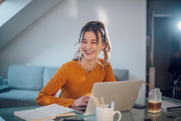 Woman having web call on a laptop while working at home