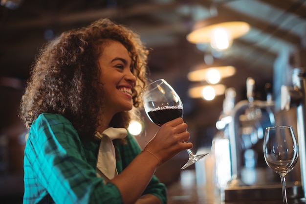 Donna che mangia vino al bancone del bar