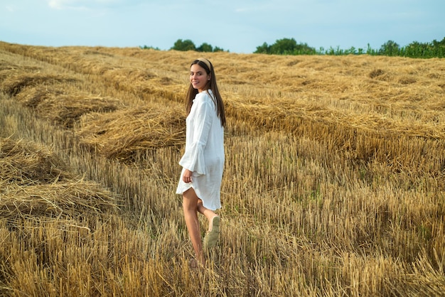 Woman in the hay field Girl in white shirt in countryside