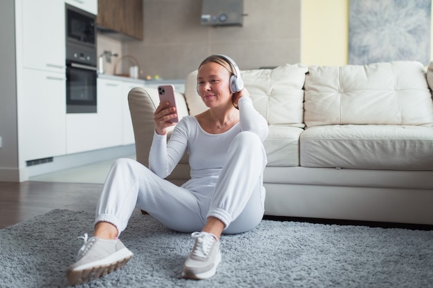 woman in headphones hold smartphone  listen music or video chat