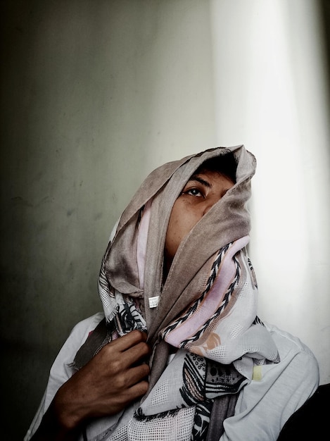 Photo woman in headscarf against wall