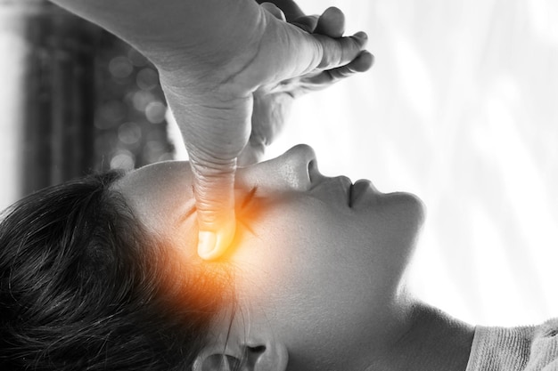 Woman during healing head massage therapy in Asian traditional clinic