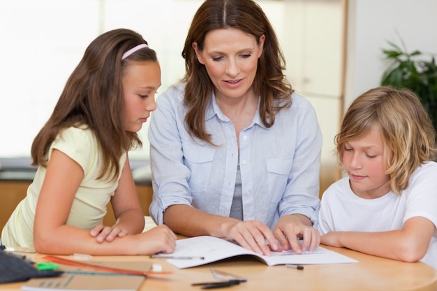 Woman helping children with homework