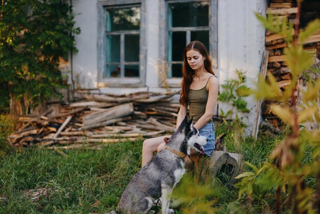 女と彼女のハスキー犬は,木の間で公園で幸せに野外で遊んで,秋に歯で微笑んで,彼女のペットと散歩します. 高品質の写真