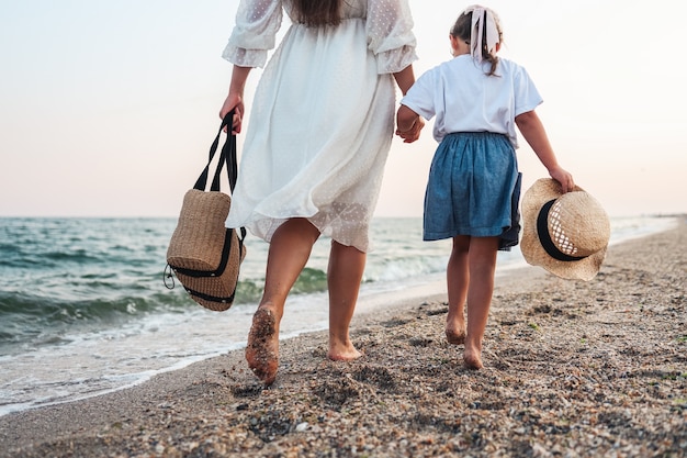 Woman and her little daughter on the beach