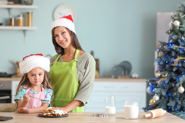 Woman and her little daughter preparing Christmas cookies at home