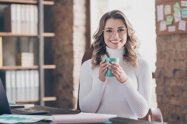 Donna nel suo ufficio a bere caffè