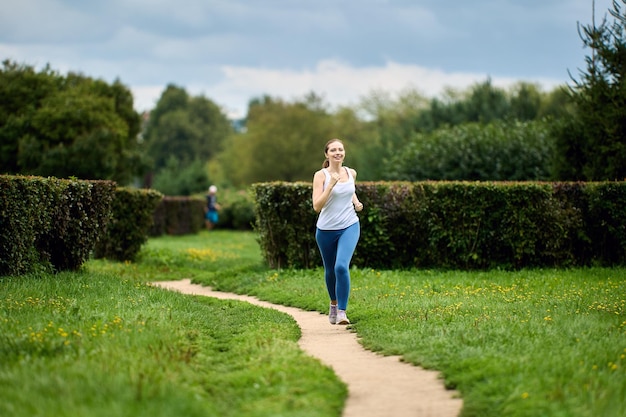 Woman in her s runs in public park in summer