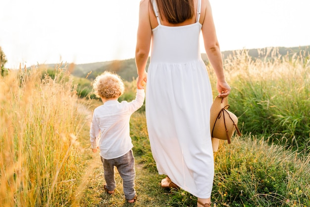 Woman and her son are walking in summer field