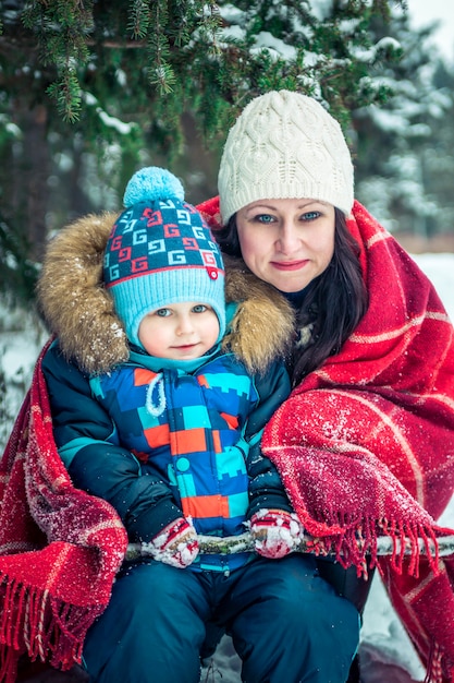 Foto donna e suo figlio nella foresta di inverno