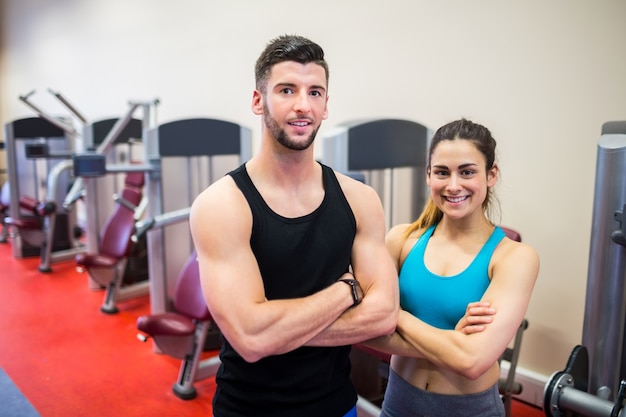 Woman and her trainer by the weights machines