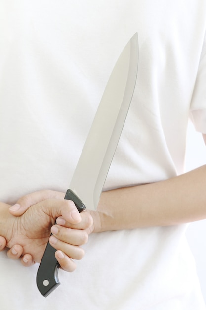 Woman hiding kitchen knife.