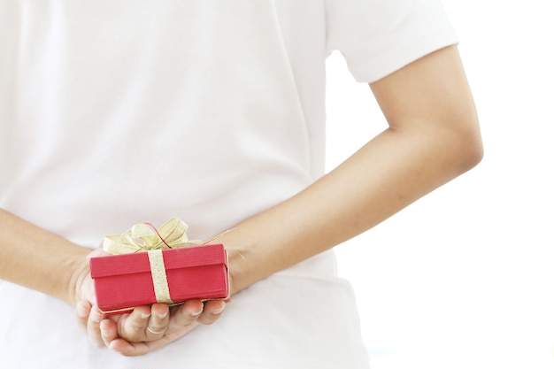 Woman hiding red gift box behind her back