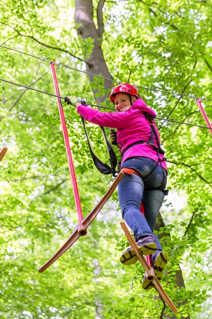 Woman in high rope course or park climbing