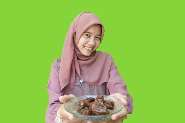 A woman in a hijab holds a plate of food