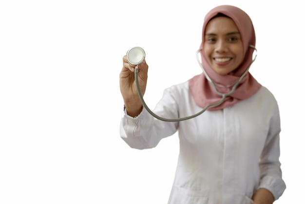 A woman in a hijab holds a stethoscope.