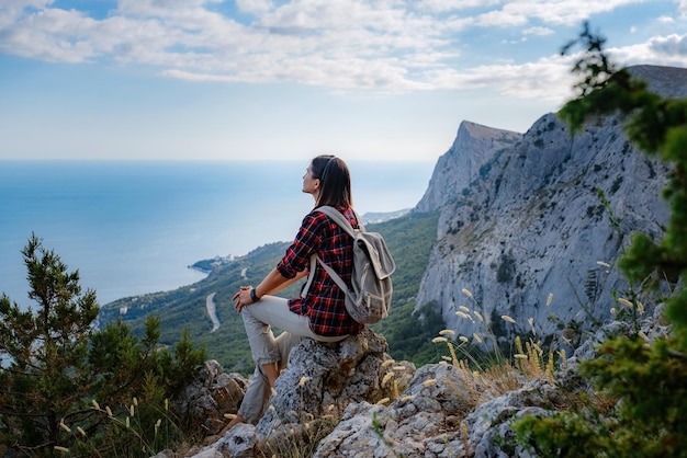 Woman hiker enjoy the view at sunset mountain peak cliff