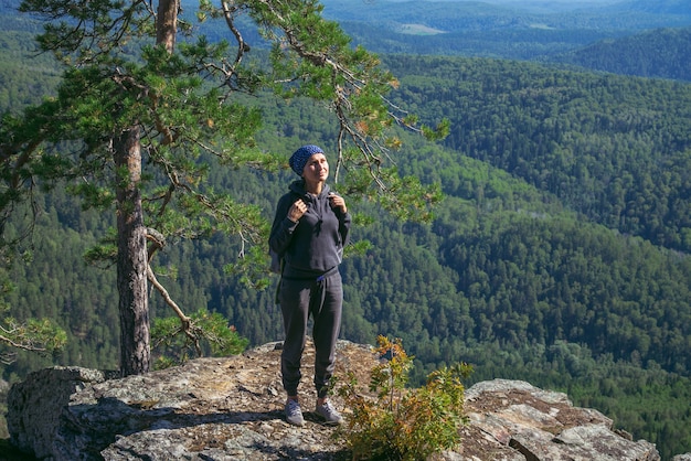 Photo woman hiker enjoying the view from top of a mountain in sunny summer day