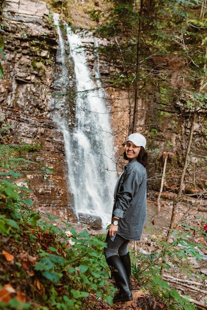 Woman hiker enjoying view of waterfall copy space