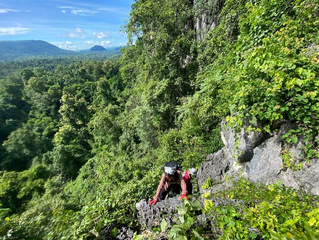 秋の晴れた日に山の頂上を歩く女性ハイカーハイキングバックパッカー旅行キャンピングカー