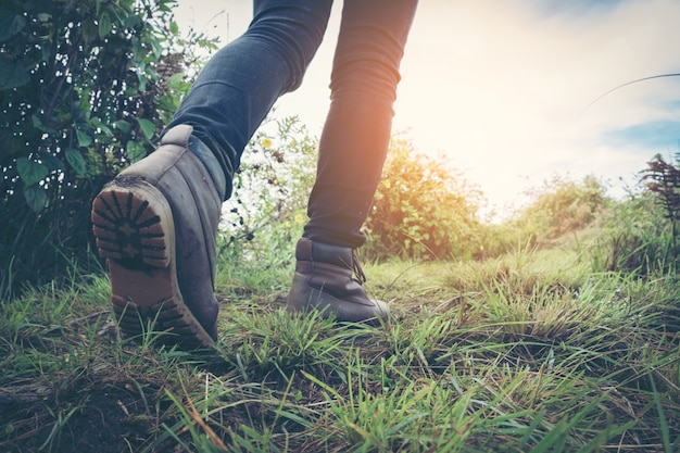 woman hiker hiking in rocky mountains. Active woman backpacker traveling on the nature.