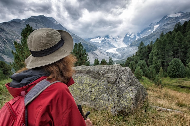 Woman hiker looks high mountain