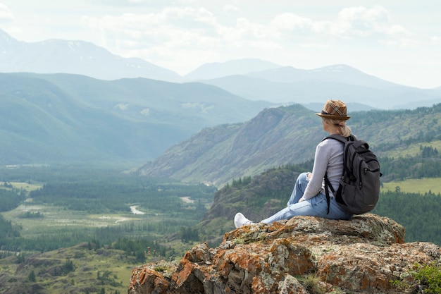 Woman hiker relaxing alone in mountain top.