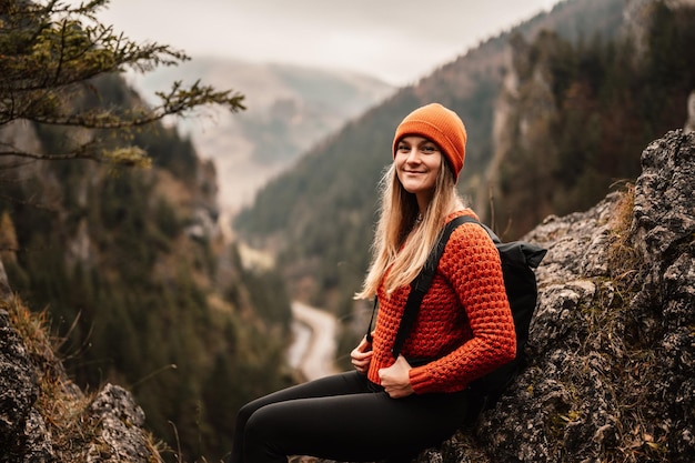 Woman hiker sits and enjoys valley view from viewpoint Hiker reached top of the mountain and relaxes Slovakia mala fatra Adventure and travel in the mountains region