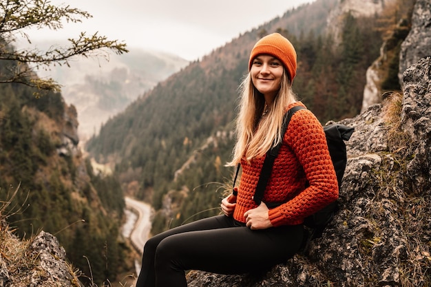 Woman hiker sits and enjoys valley view from viewpoint Hiker reached top of the mountain and relaxes Slovakia mala fatra Adventure and travel in the mountains region