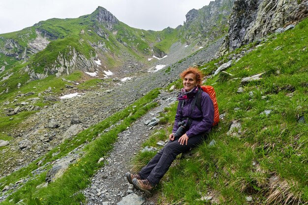 Woman hiker with backpack resting after a long trail