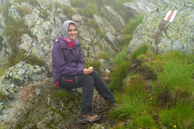 Woman hiker with backpack resting after a long trail