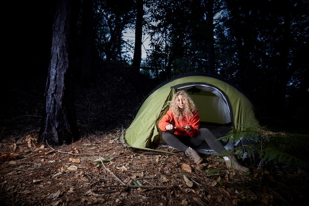 Woman hiker with tent in the forest