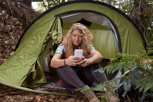 Woman hiker with tent in the forest