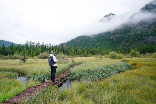 Woman Hiking In Autumn Forest Trail.