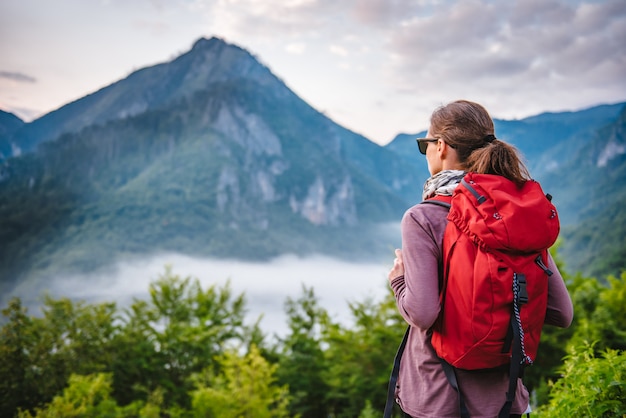 Woman hiking on the mountain and looking at sunrise