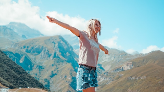 Woman hiking in mountains at sunny day time