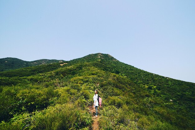 사진 하늘을 배경으로 초록색 풍경에서 하이킹하는 여성